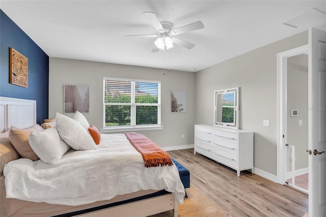 bedroom featuring ceiling fan, light hardwood / wood-style flooring, and multiple windows