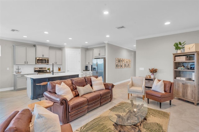 living room featuring sink, light tile patterned flooring, and ornamental molding