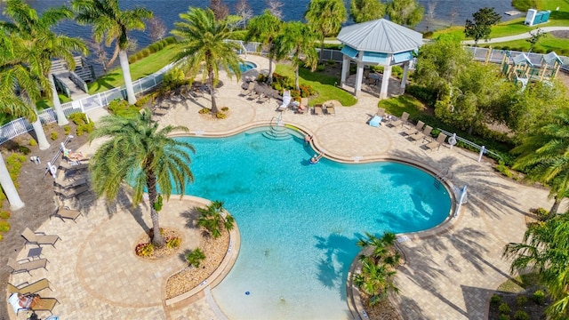 community pool with a patio area, fence, and a gazebo