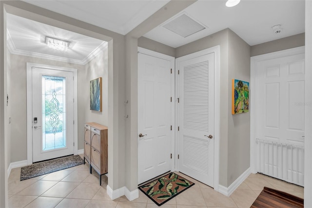 entryway featuring visible vents, crown molding, baseboards, and light tile patterned floors