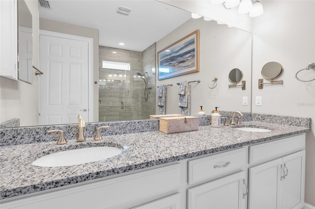 full bathroom featuring visible vents, a sink, a shower stall, and double vanity