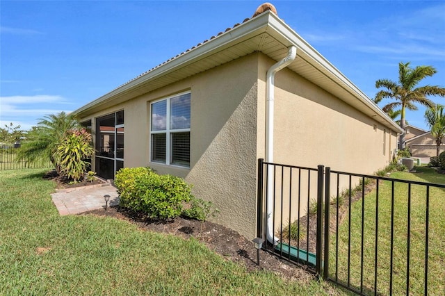 view of home's exterior featuring a yard, fence, and stucco siding