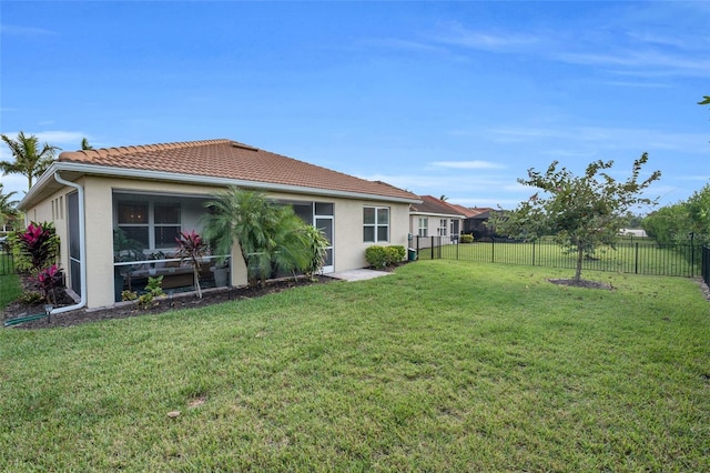 back of property featuring a yard, a fenced backyard, a tiled roof, and stucco siding