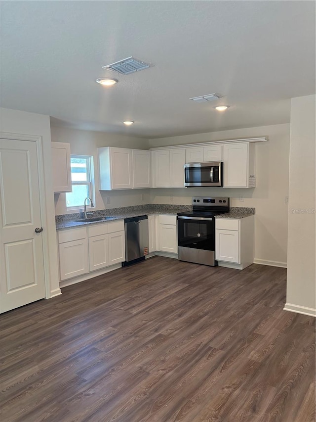 kitchen featuring white cabinetry, appliances with stainless steel finishes, dark hardwood / wood-style floors, and sink