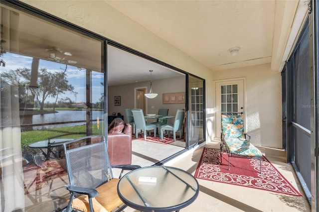 sunroom / solarium featuring a water view