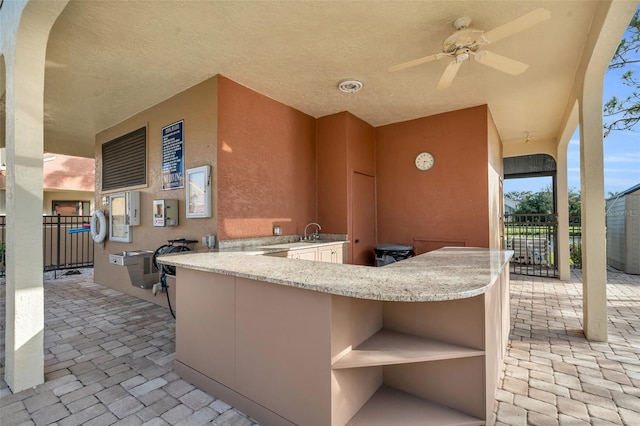 view of patio / terrace featuring ceiling fan and a wet bar