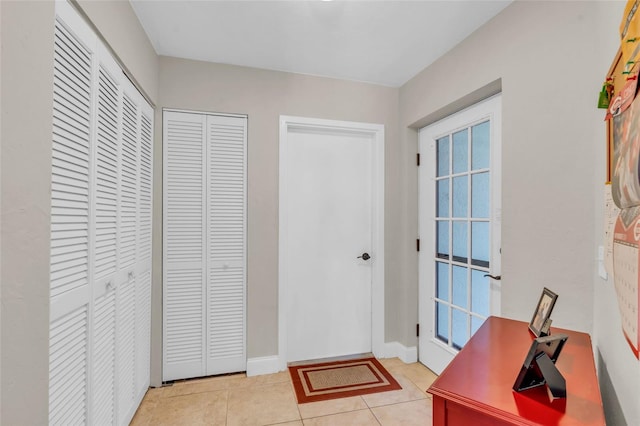 doorway with light tile patterned flooring and a wealth of natural light