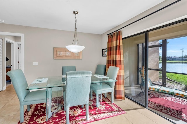 tiled dining room featuring a water view