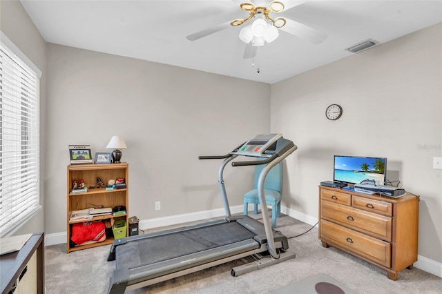 exercise area featuring ceiling fan and light colored carpet