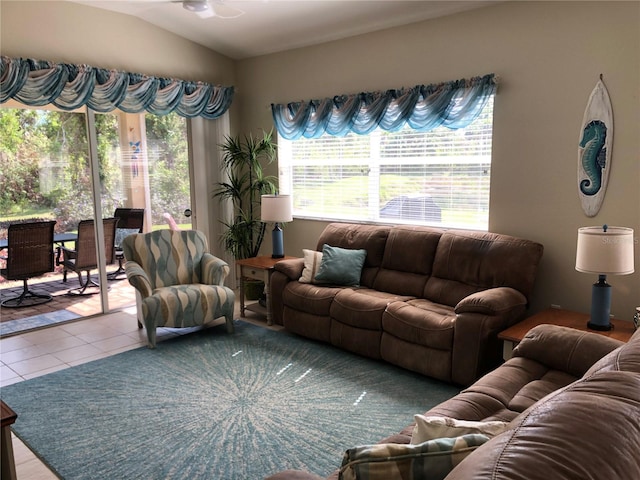 living room featuring tile patterned floors, a healthy amount of sunlight, and lofted ceiling