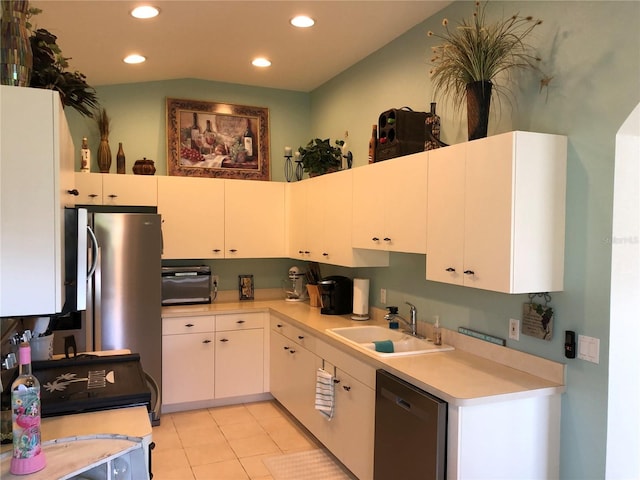 kitchen with white cabinets, light tile patterned floors, stainless steel dishwasher, and sink