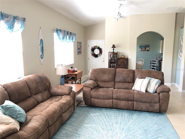 living room featuring lofted ceiling, ceiling fan, and light tile patterned floors