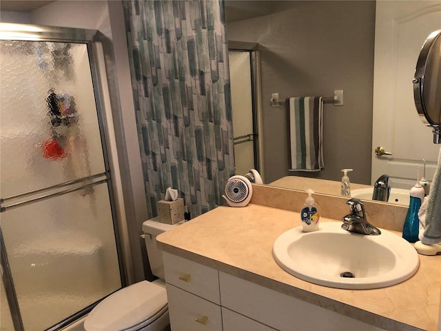 bathroom with toilet, vanity, and walk in shower