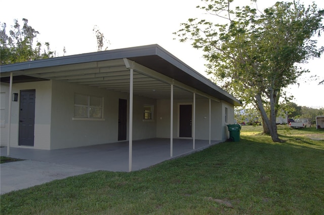 exterior space featuring a carport and a lawn