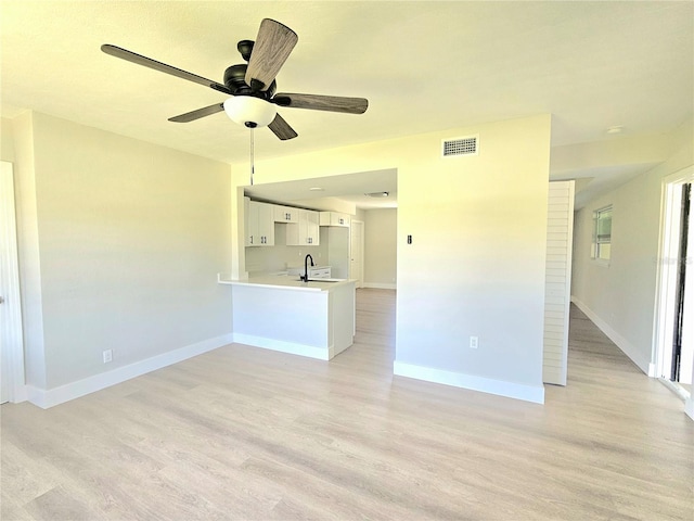 unfurnished living room featuring ceiling fan, light hardwood / wood-style flooring, and sink