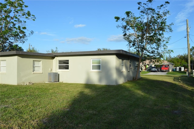 view of home's exterior featuring central air condition unit and a yard