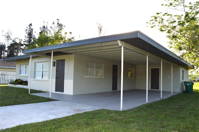 back of property with a lawn and a carport