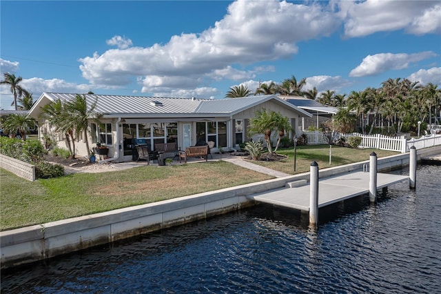 back of property with a patio area, outdoor lounge area, a yard, and a water view