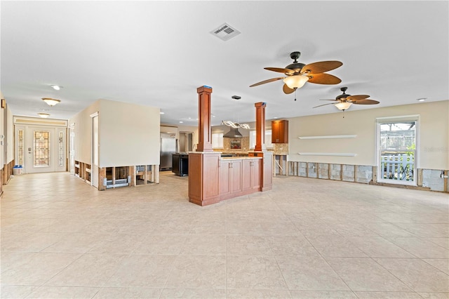 unfurnished living room with light tile patterned floors, ornate columns, and ceiling fan