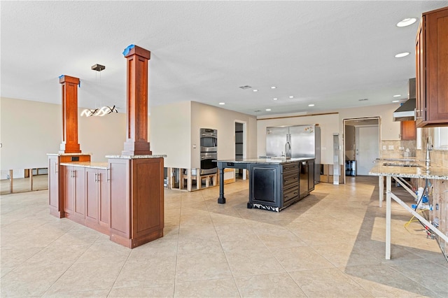 kitchen with a center island, stainless steel appliances, decorative columns, decorative light fixtures, and decorative backsplash