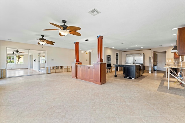 unfurnished living room with light tile patterned floors and decorative columns