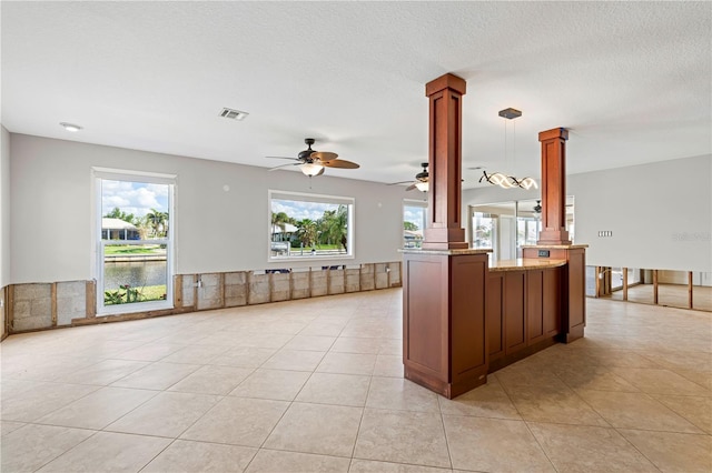 kitchen featuring ceiling fan, hanging light fixtures, decorative columns, kitchen peninsula, and light tile patterned flooring