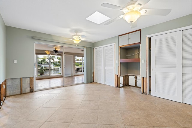 interior space featuring ceiling fan and a skylight