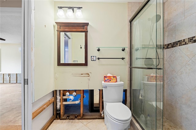 bathroom featuring tile patterned floors, toilet, and walk in shower