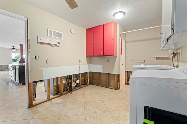 washroom featuring cabinets, a textured ceiling, ceiling fan, washing machine and dryer, and light tile patterned flooring