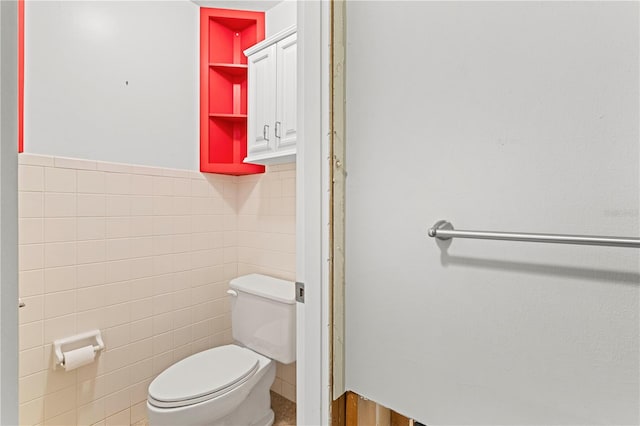 bathroom featuring tile walls and toilet