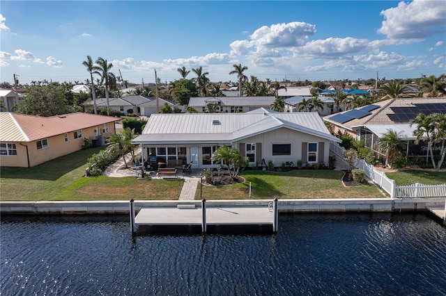 back of house with a water view, a yard, and a patio