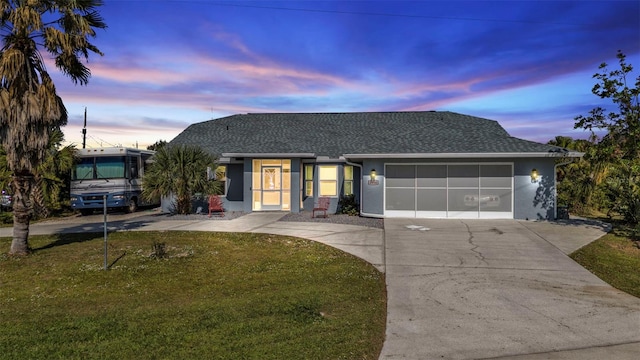 ranch-style house featuring a garage and a yard