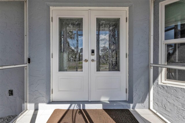 5198 White Ave, Port Charlotte, FL 33981 - doorway to property with french doors and stucco siding