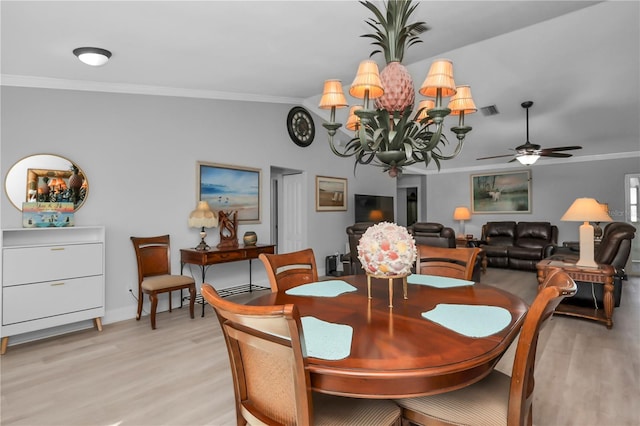 5198 White Ave, Port Charlotte, FL 33981 - dining area featuring light wood-type flooring, crown molding, ceiling fan, baseboards, and a chandelier