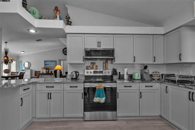 5198 White Ave, Port Charlotte, FL 33981 - kitchen with stainless steel appliances, vaulted ceiling, a peninsula, decorative backsplash, and ornamental molding