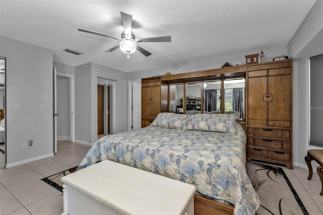 5198 White Ave, Port Charlotte, FL 33981 - bedroom with light tile patterned flooring, baseboards, a textured ceiling, and a ceiling fan
