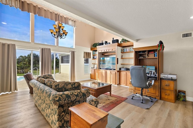 office area with high vaulted ceiling, light hardwood / wood-style floors, a textured ceiling, and an inviting chandelier