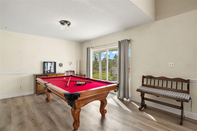 game room featuring a textured ceiling, hardwood / wood-style flooring, and billiards