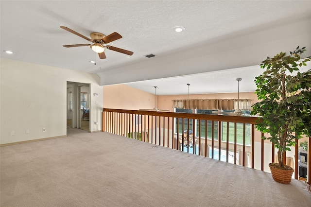 unfurnished room featuring carpet, a textured ceiling, and ceiling fan