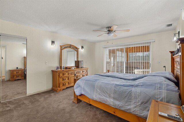 bedroom featuring ceiling fan, a closet, carpet floors, and a textured ceiling