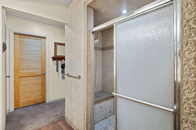 bathroom with hardwood / wood-style floors and a shower with door