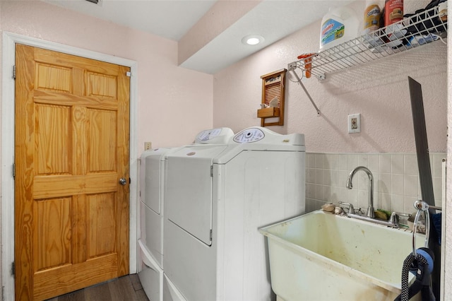 laundry room featuring dark hardwood / wood-style flooring, washing machine and dryer, and sink