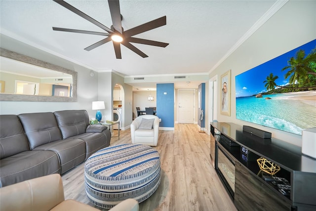 living room featuring ceiling fan, light hardwood / wood-style floors, washer / dryer, and crown molding