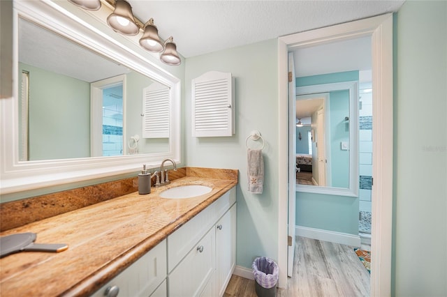 bathroom featuring hardwood / wood-style floors, vanity, and a textured ceiling