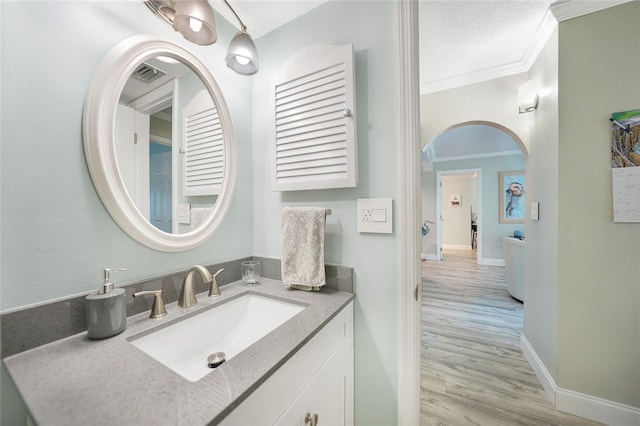 bathroom featuring vanity, wood-type flooring, and ornamental molding