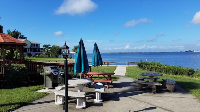 exterior space with a water view and grilling area