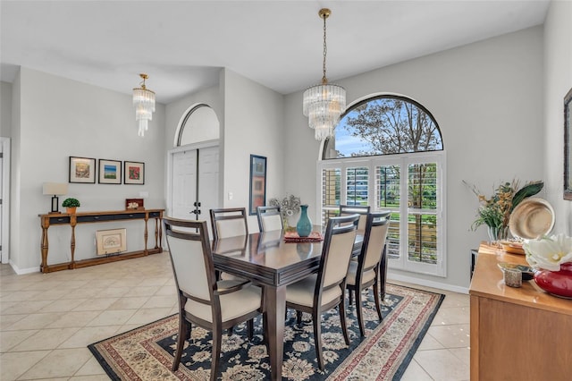 dining space with a notable chandelier, light tile patterned floors, a high ceiling, and a wealth of natural light