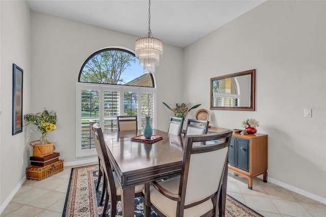 dining room with a high ceiling, an inviting chandelier, and light tile patterned flooring