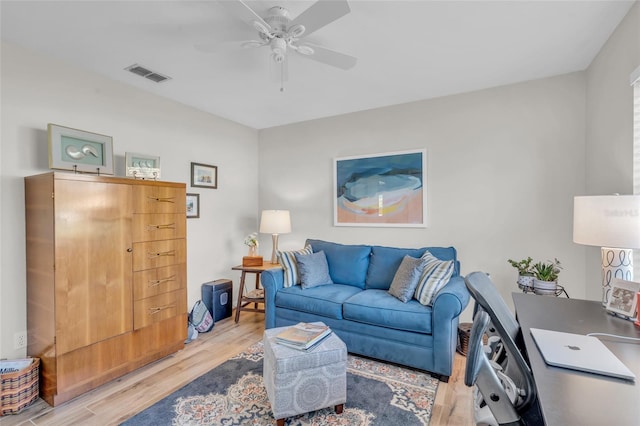 living room featuring ceiling fan and light hardwood / wood-style flooring