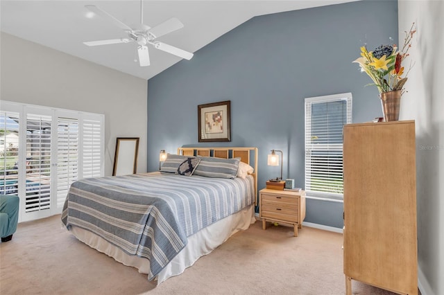 carpeted bedroom with multiple windows, ceiling fan, and high vaulted ceiling